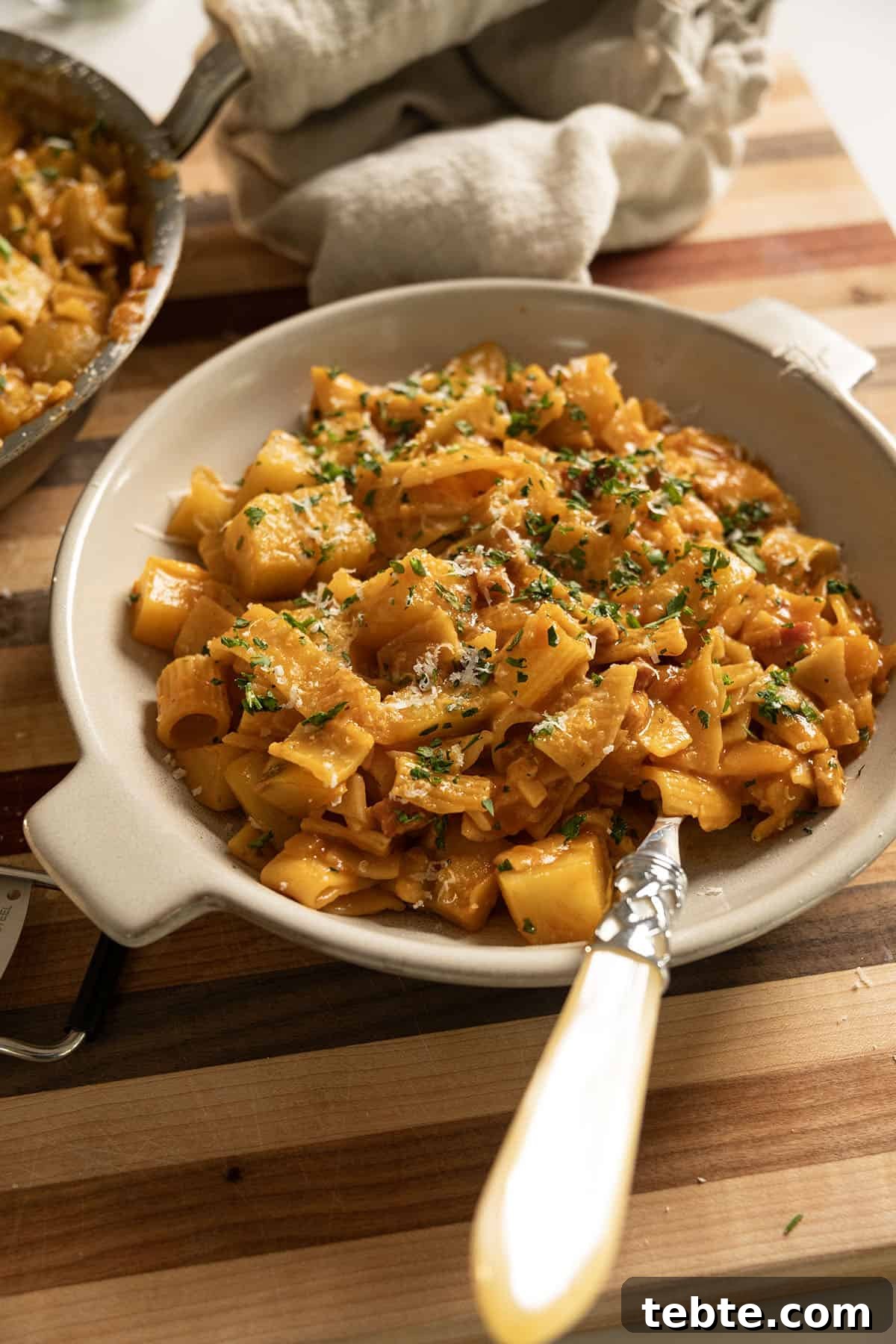 Pasta and Potatoes on a plate topped with parsley and parmesan.