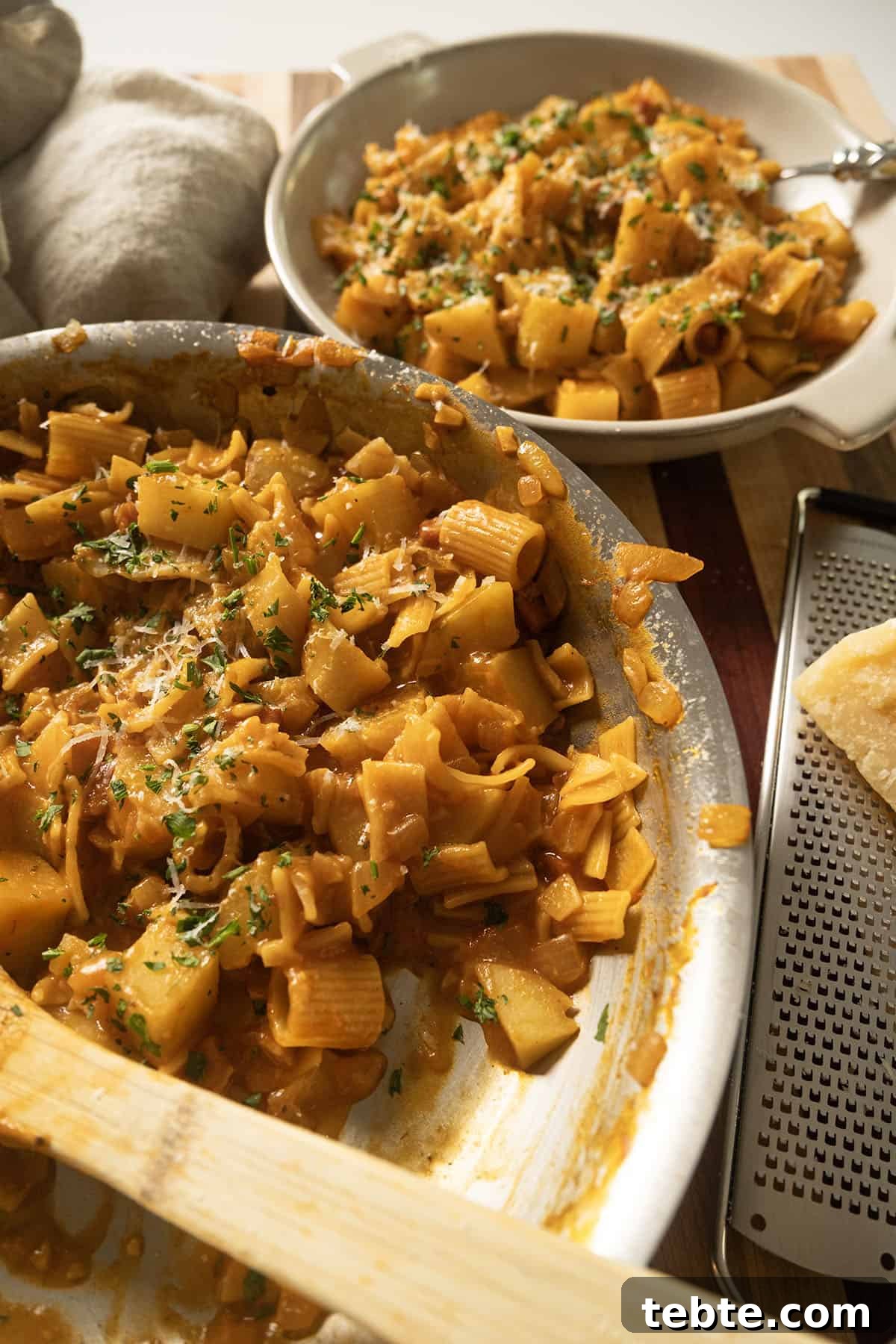 Pasta and Potatoes on a plate topped with parsley and parmesan.