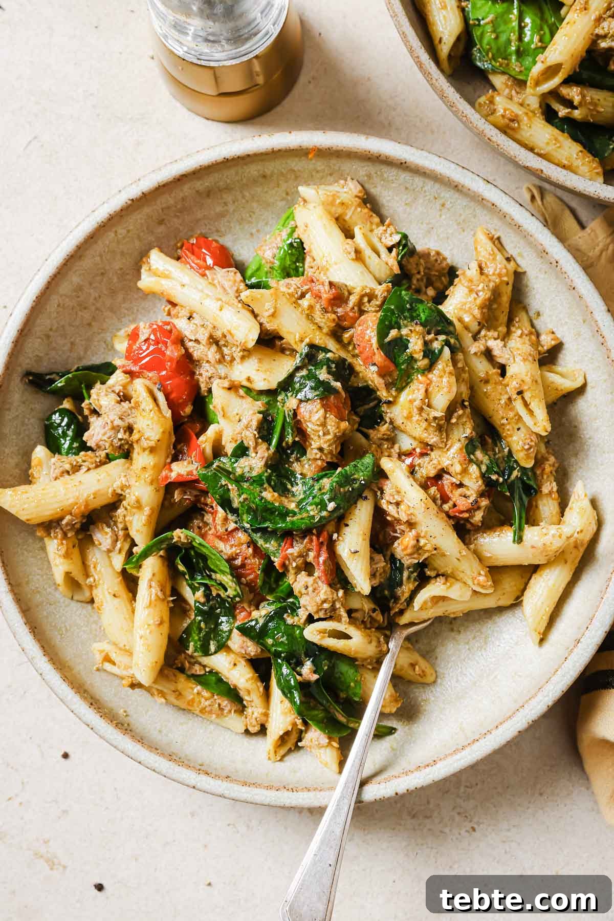 Creamy Tuna Pesto Pasta Recipe for Quick Weeknight Meals 11 A bowl of tuna pesto pasta with a fork.
