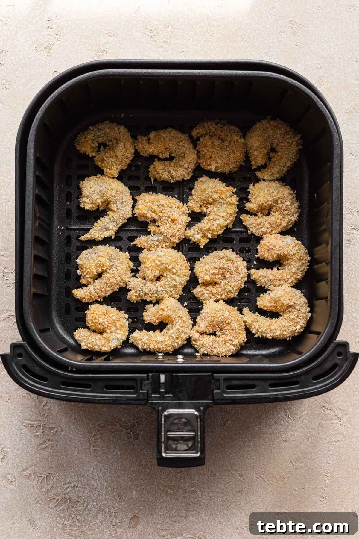 Crispy Air Fryer Breaded Shrimp Recipe for Quick Dinner 5 Overhead view of raw breaded shrimp in an air fryer basket.