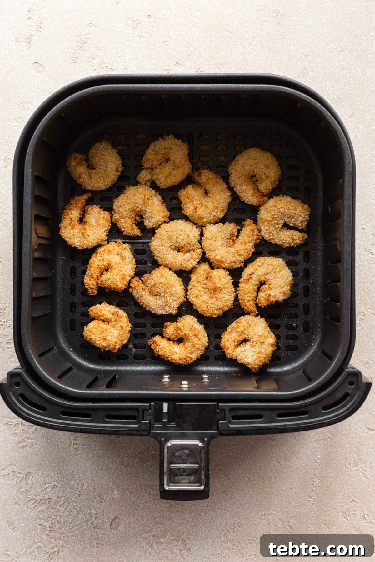 Crispy Air Fryer Breaded Shrimp Recipe for Quick Dinner 6 Overhead view of air fried breaded shrimp in an air fryer basket.