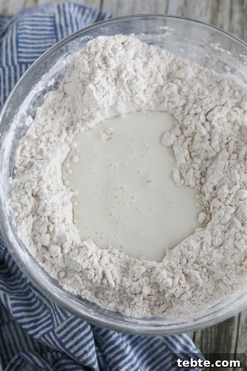 Flaky Homemade Biscuits Recipe — From Scratch and Delicious 5 buttermilk being combined with butter and flour