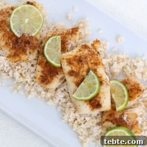 Air Fryer Cod with 3 Ingredients — Quick Crispy Recipe 5 Air-fried cod topped with seasoning and slices of fresh lime on a white dish.