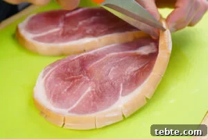 Classic Gammon Steak with Fried Egg and Chips 4 Snipping the fat edges of a gammon steak with scissors