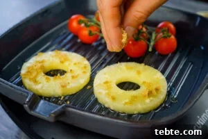 Classic Gammon Steak with Fried Egg and Chips 6 Two pineapple rings and vine cherry tomatoes cooking on a griddle pan