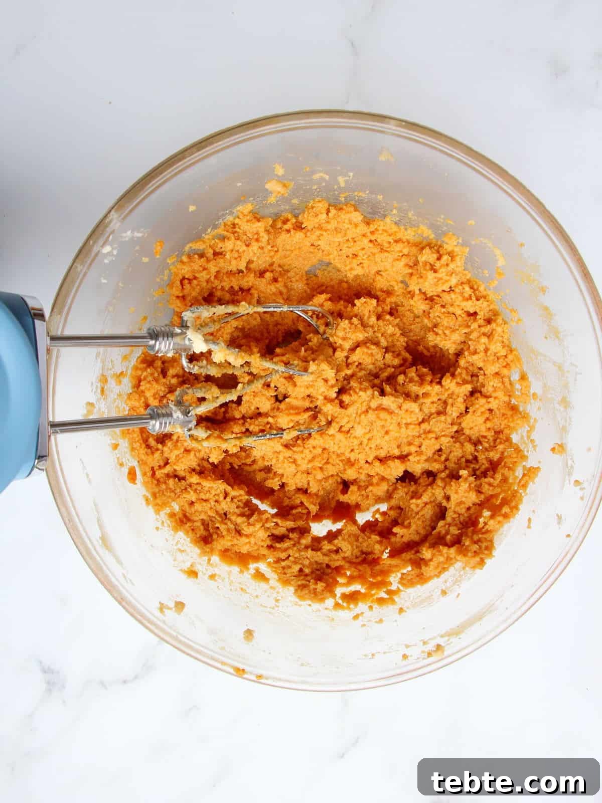Pumpkin Cheesecake Cookies Recipe — Soft, Creamy Fall Treat 11 wet ingredients for pumpkin cookiescombined with electric mixer in transparent bowl