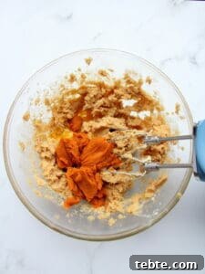 Pumpkin Cheesecake Cookies Recipe — Soft, Creamy Fall Treat 23 adding pumpkin puree to creamed brown sugar
