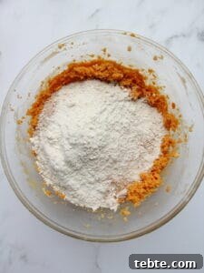 Pumpkin Cheesecake Cookies Recipe — Soft, Creamy Fall Treat 25 dry ingredients tossed into wet ingredients for pumpkin cookies in transparent bowl