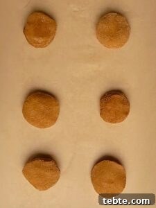 Pumpkin Cheesecake Cookies Recipe — Soft, Creamy Fall Treat 28 pumpkin cookies on brown parchment paper