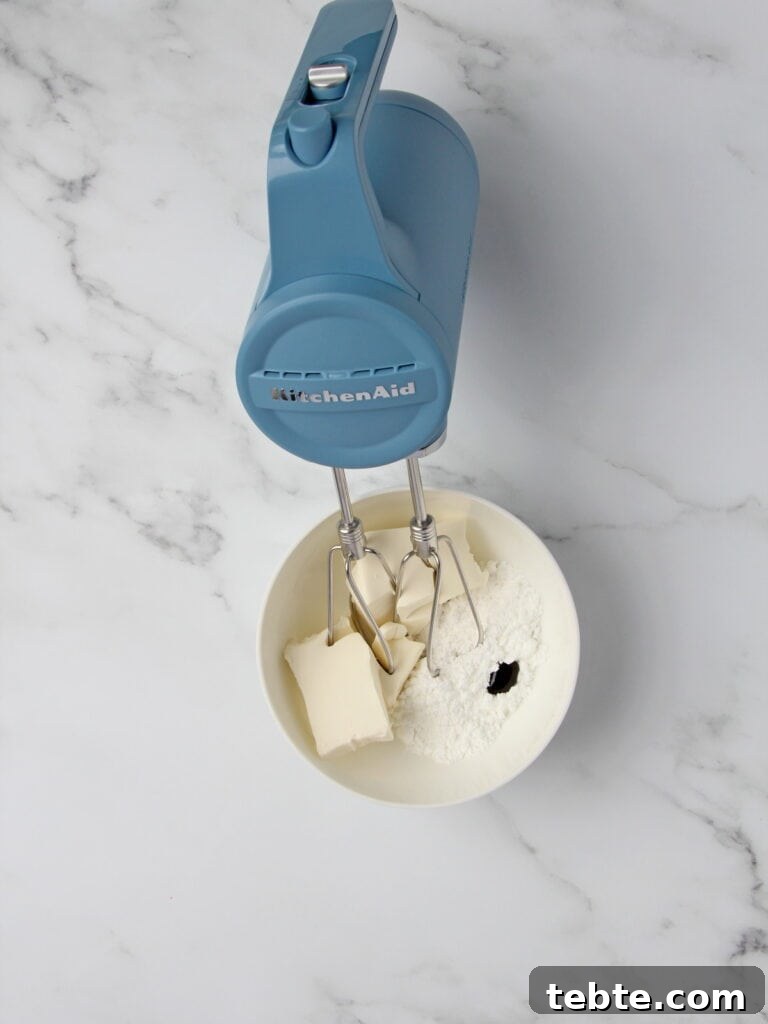 Pumpkin Cheesecake Cookies Recipe — Soft, Creamy Fall Treat 5 ingredients for cream cheese filling in white bowl mixed with KitchenAid cordless mixer