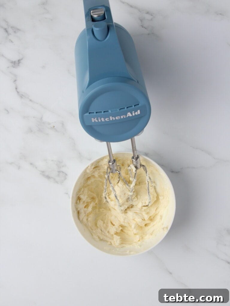 Pumpkin Cheesecake Cookies Recipe — Soft, Creamy Fall Treat 6 cheesecake filling being combined in white bowl with handheld mixer
