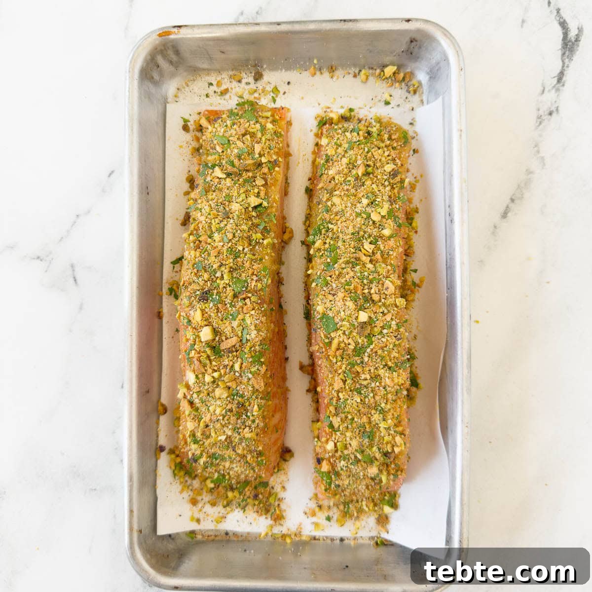 Oven-Roasted Salmon with Pistachio Crust 6 Pieces of salmon with a pistachio crust patted on top.
