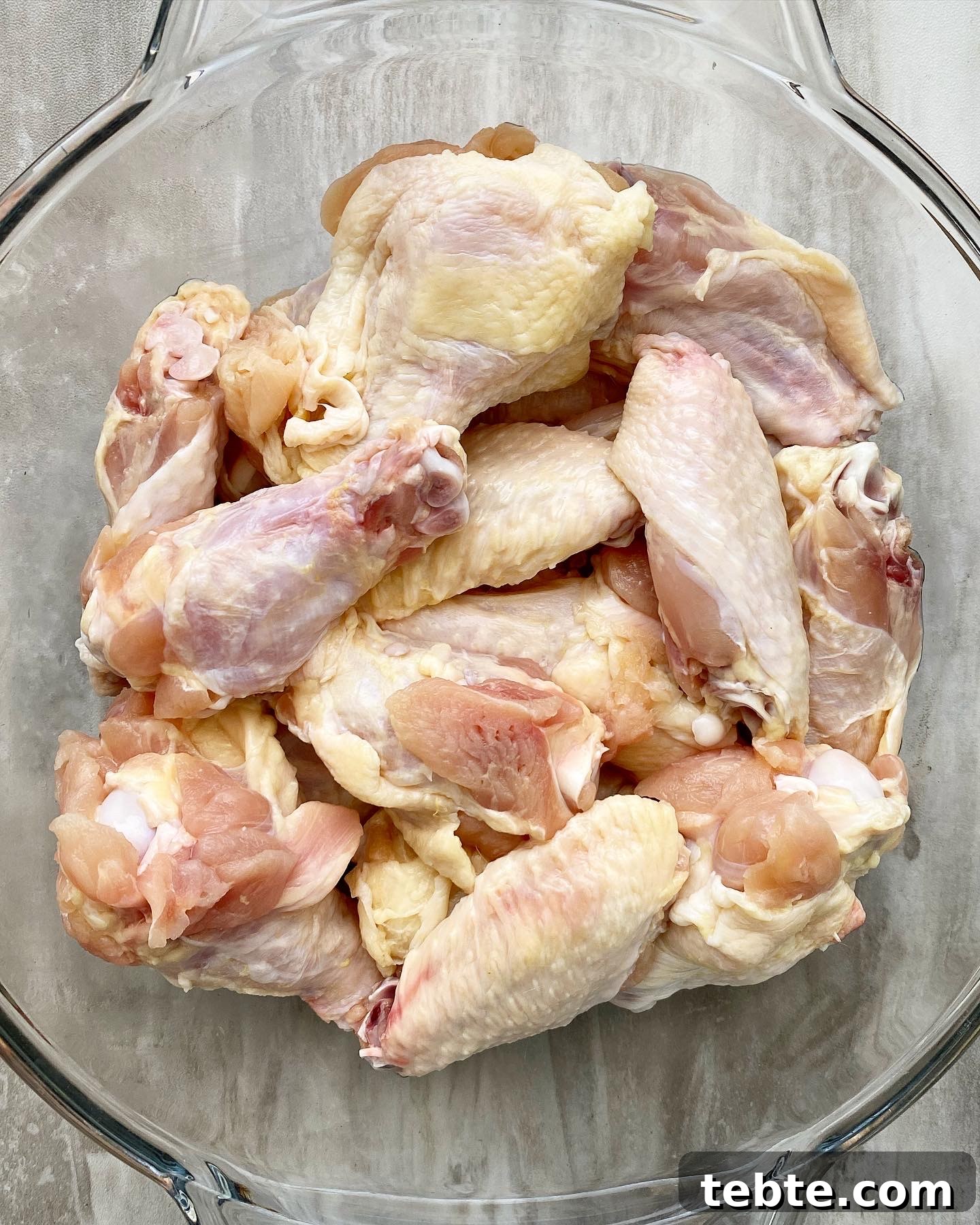 close up overhead shot of raw party chicken wings in a clear bowl