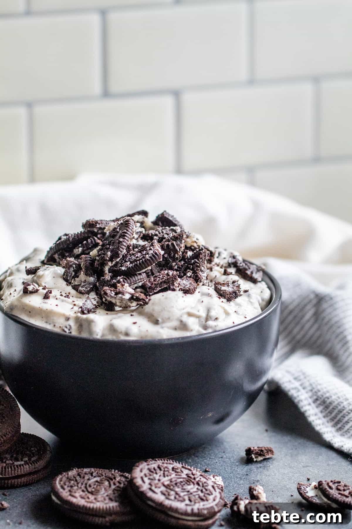 Creamy Oreo Dip Recipe for Parties and Dessert Tables 2 Oreo dip in black bowl on dark gray table.