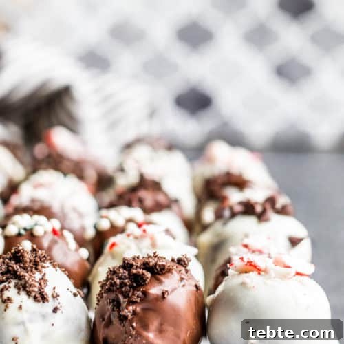 Strait on shot of Oreo truffle balls on parchment paper in three lines on a blue counter.