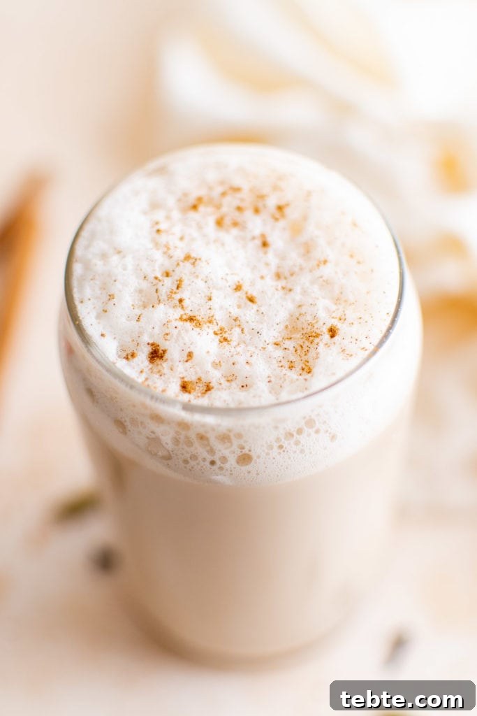 Refreshing Iced Chai Latte Recipe for Creamy Spiced Iced Tea 2 Top down view of iced latte with frothed milk and cinnamon.
