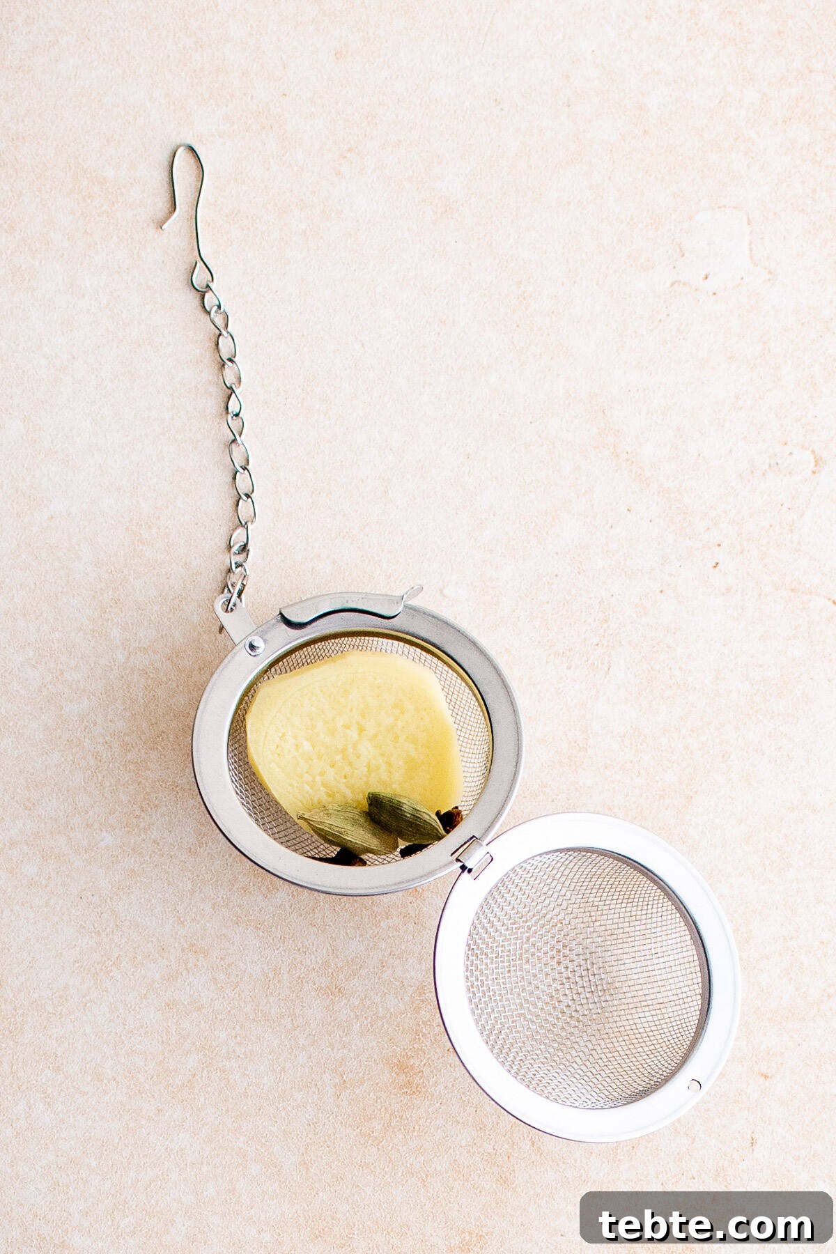Refreshing Iced Chai Latte Recipe for Creamy Spiced Iced Tea 4 Top down view of an open tea ball with chai latte ingredients.