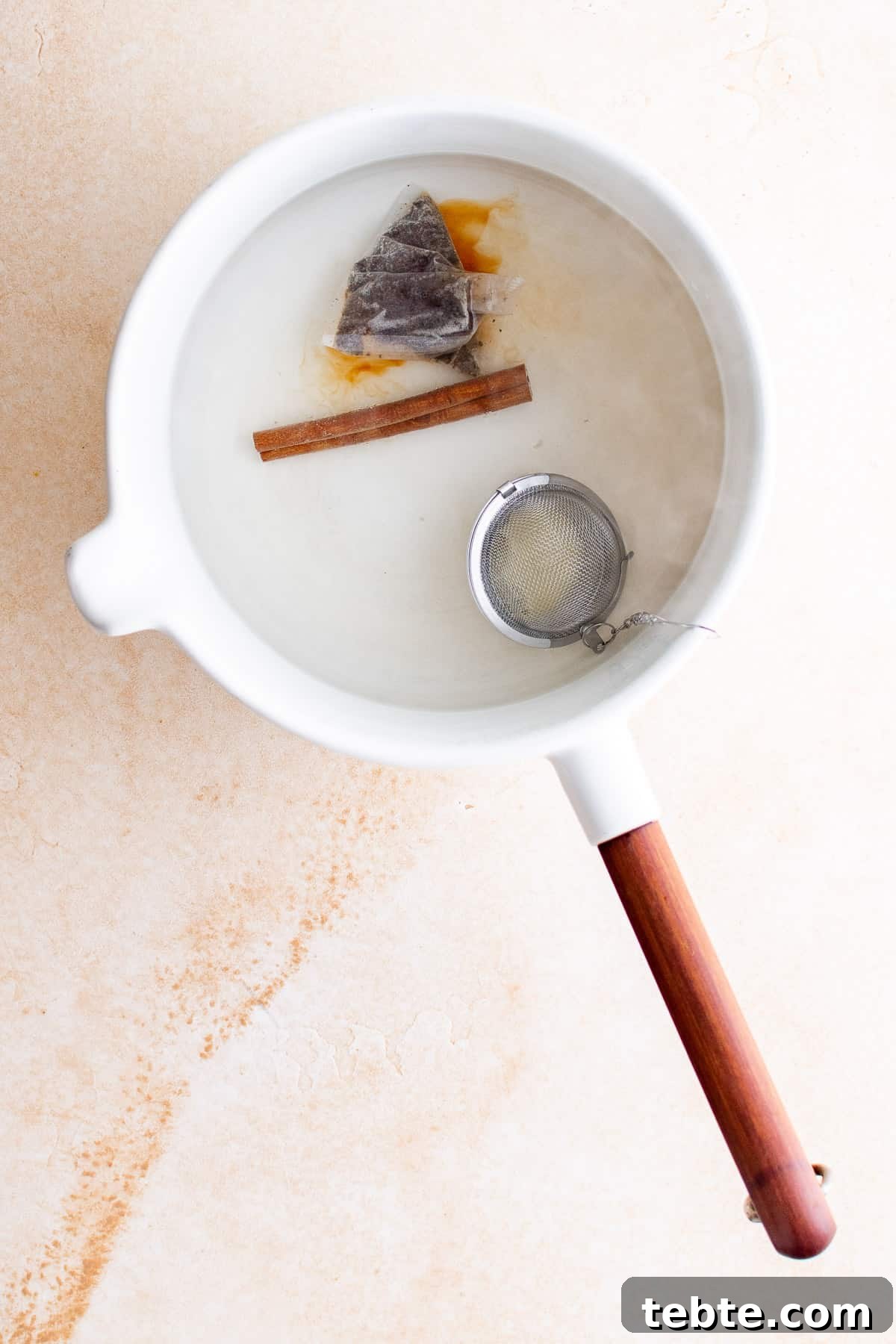 Refreshing Iced Chai Latte Recipe for Creamy Spiced Iced Tea 5 Top down view of ingredients for spiced tea in a pan.