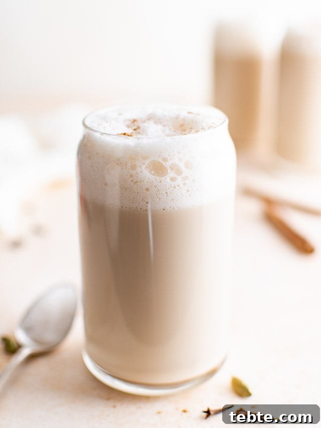 Refreshing Iced Chai Latte Recipe for Creamy Spiced Iced Tea 8 Tall glass of chai latte with cinnamon sticks.