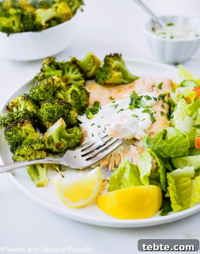 Baked Rainbow Trout Fillets with Roasted Broccoli and salad on dish.