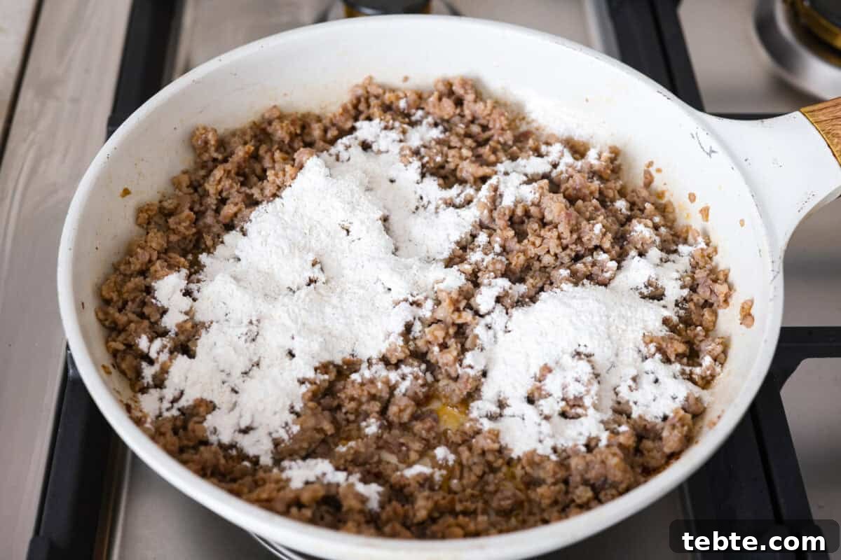 Forget the usual biscuits and gravy, this version takes everything you love and turns it into one irresistible, bubbly casserole. Creamy sausage gravy, buttery biscuits, and zero stress. Flour mixture spread over the cooked sausage.
