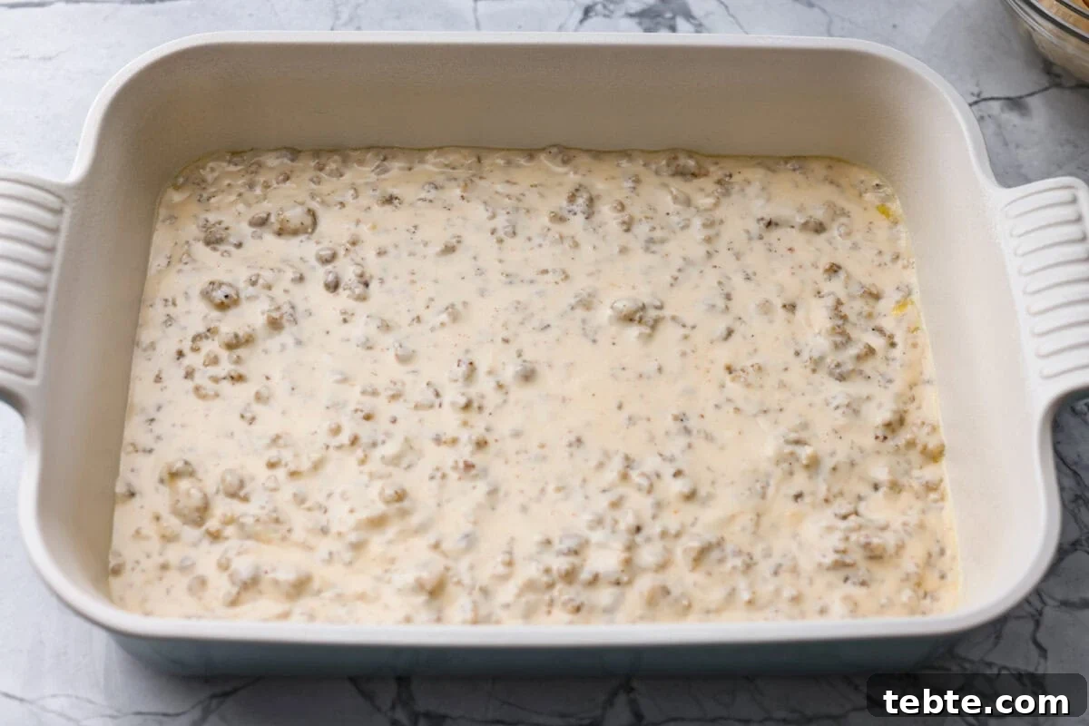 Forget the usual biscuits and gravy, this version takes everything you love and turns it into one irresistible, bubbly casserole. Creamy sausage gravy, buttery biscuits, and zero stress. Sausage gravy added to the bottom of the baking dish.