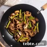 An overhead view of a wok containing homemade panda express black pepper steak.