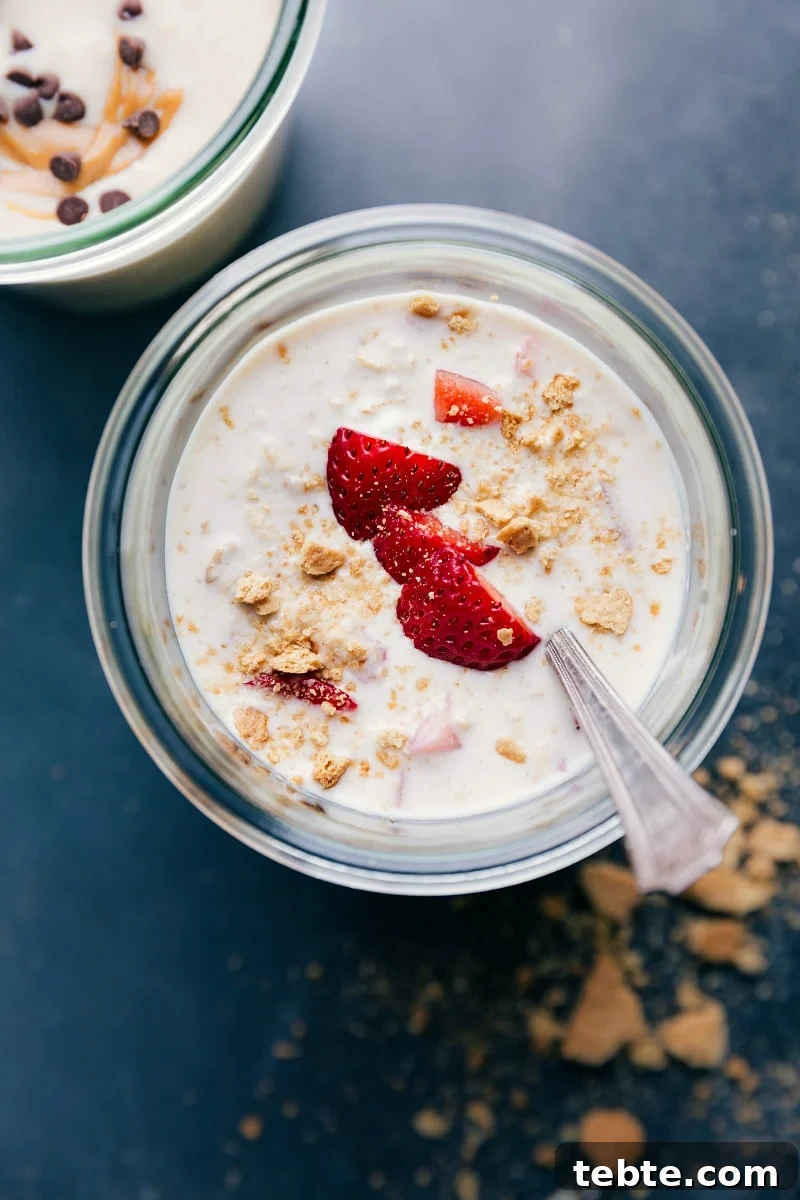 Finished strawberry cheesecake overnight oats, topped with fresh strawberries, ready for a delicious breakfast.