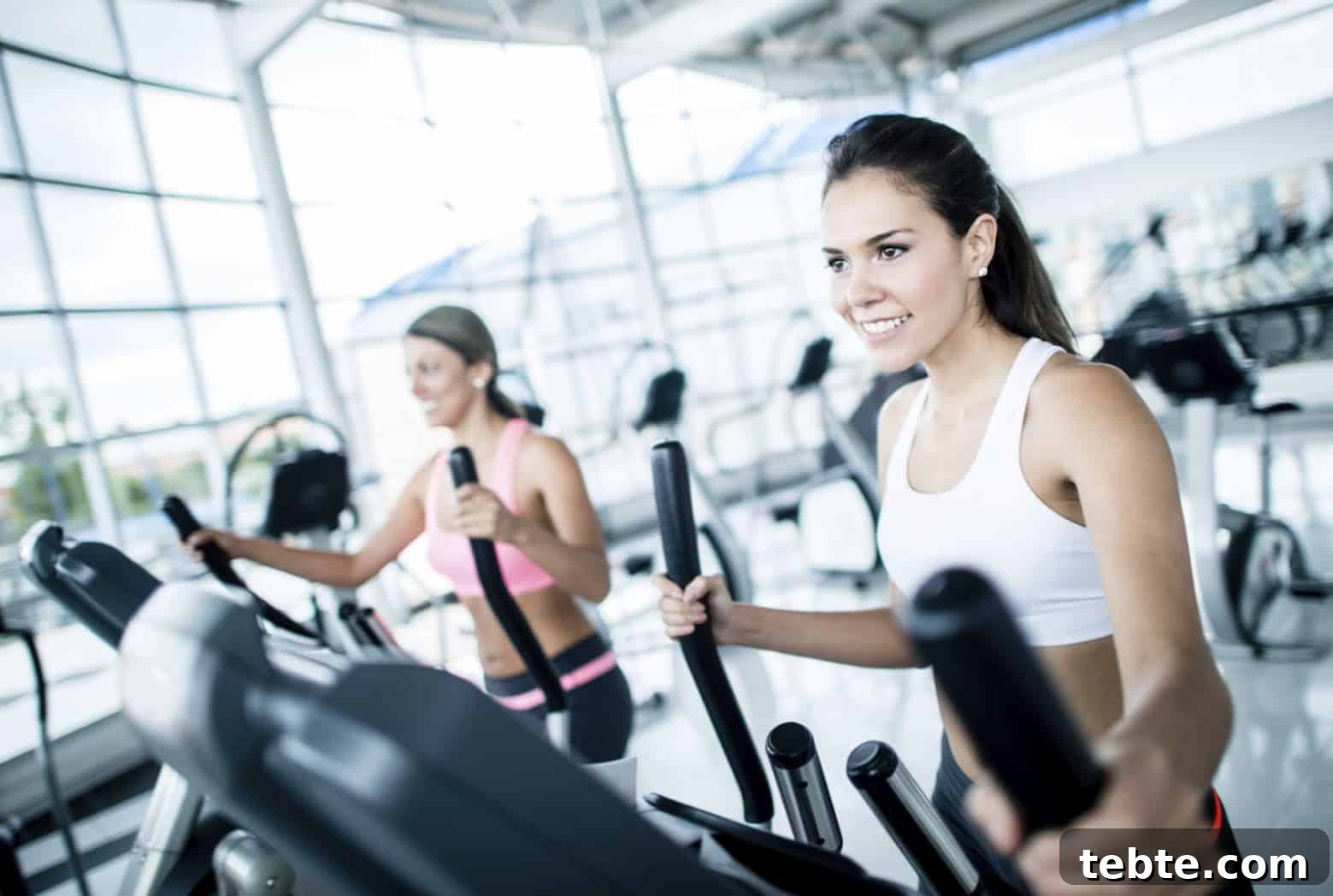 5 Cardio Workouts That Don’t Involve Running 2 Women at the gym exercising on machines