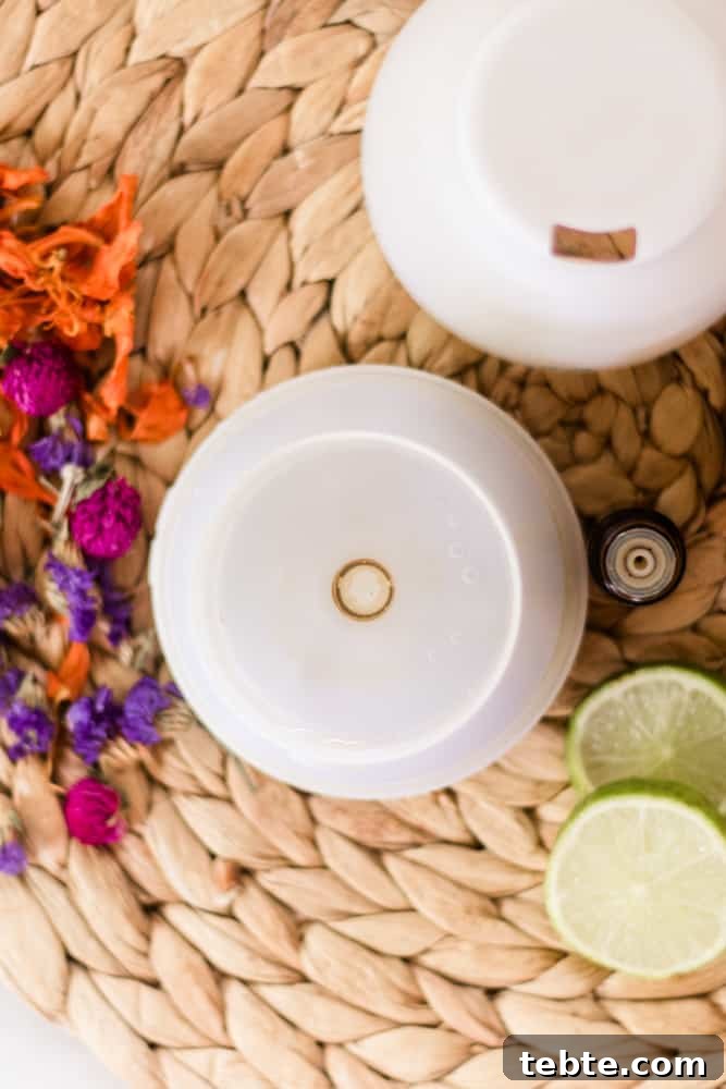 Tropical Essential Oil Diffuser Blends for Uplifting Scents 2 White diffuser open with tropical diffuser blend inside. Bright flowers all around diffuser.