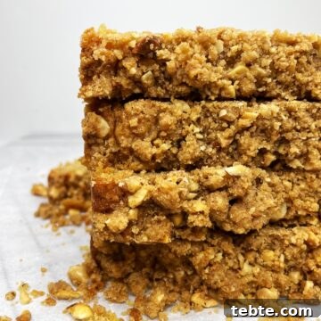 Stacked slices of apple crumble bread on parchment.