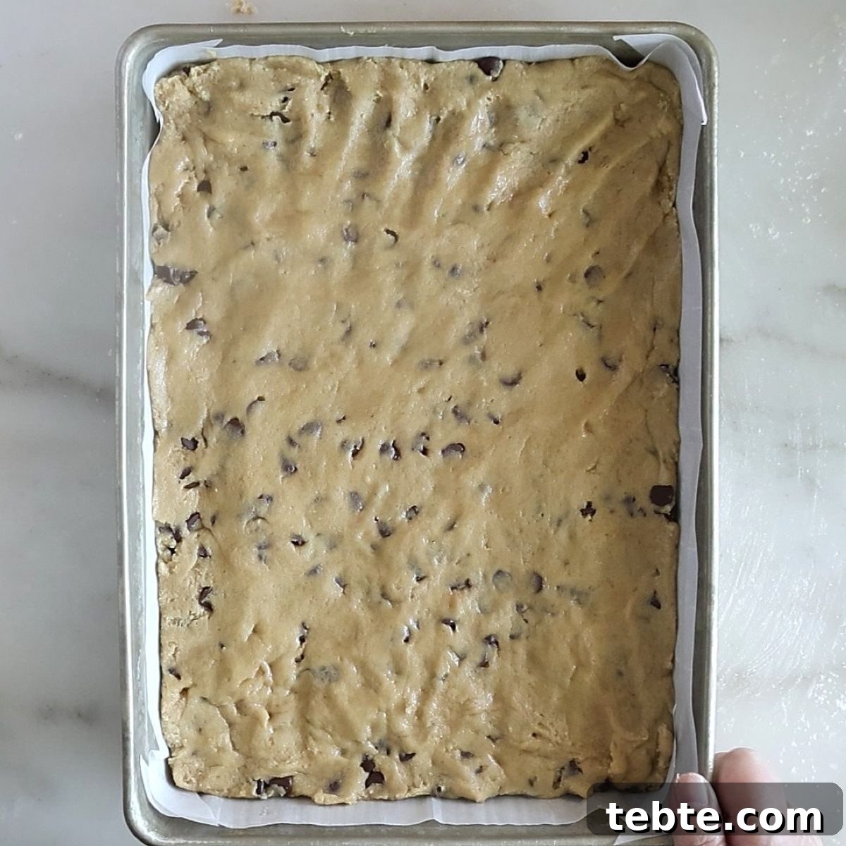 Gluten-Free Flag Cookie Cake Recipe for Patriotic Celebrations 11 cookie dough spread into parchment lined rectangular pan.