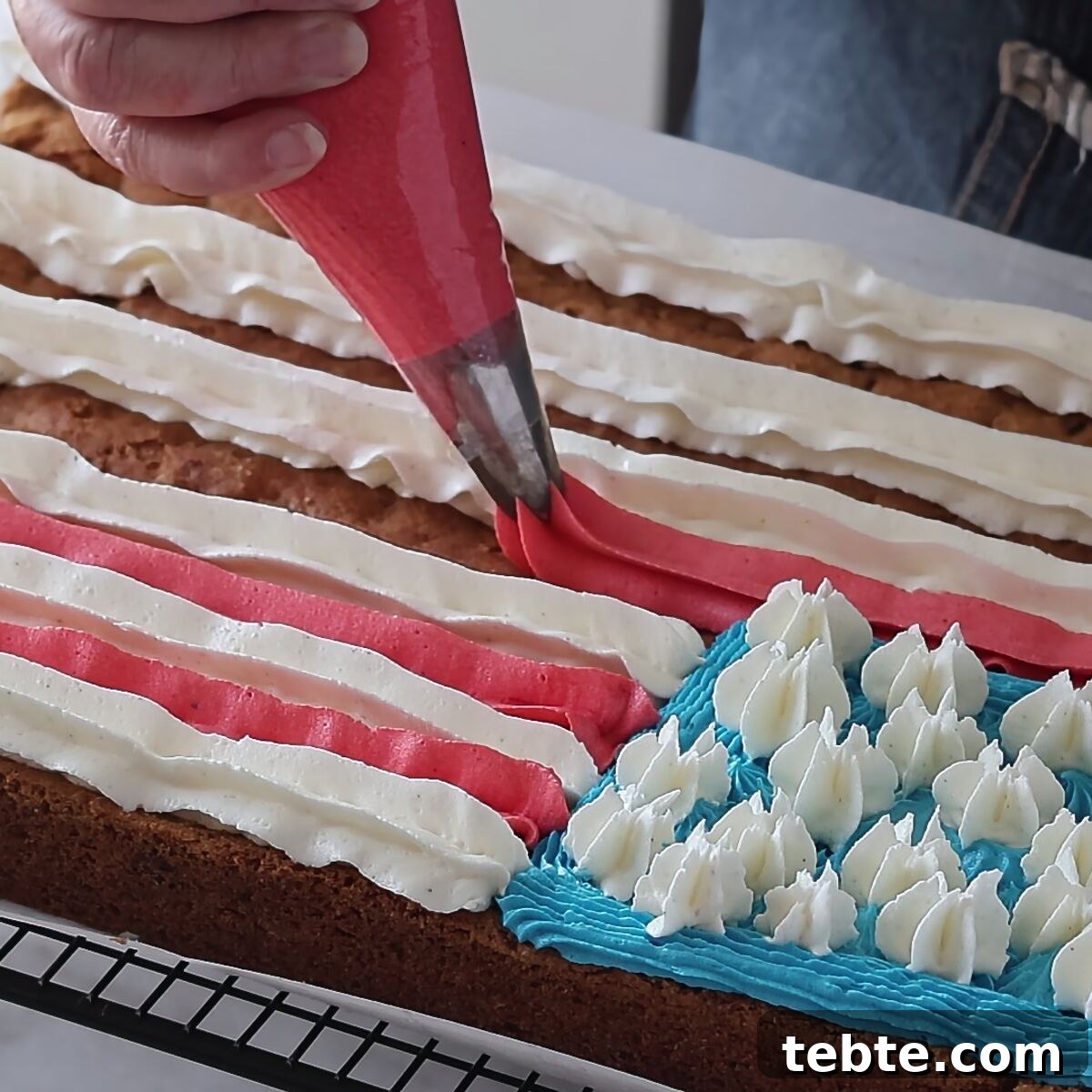Gluten-Free Flag Cookie Cake Recipe for Patriotic Celebrations 13 piping red stripes onto cookie cake for American flag.
