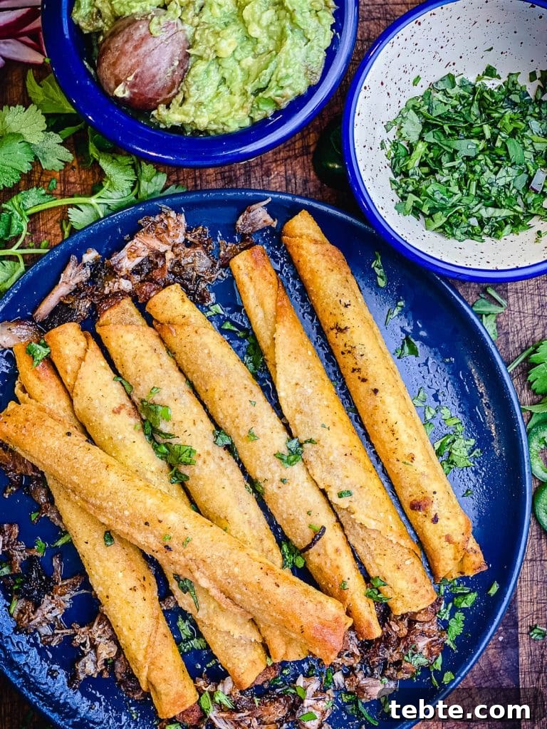 What to Make with Leftover Carnitas: Crispy Tacos & Bowls 5 pile of taquitos on a blue plate with cilantro