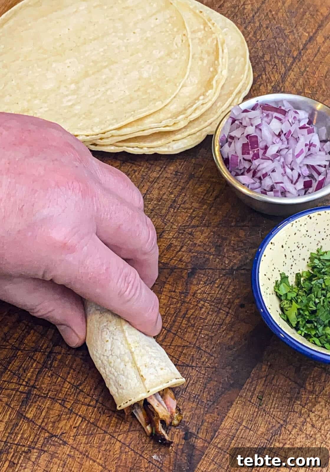 What to Make with Leftover Carnitas: Crispy Tacos & Bowls 7 rolling taquitos on a cutting board