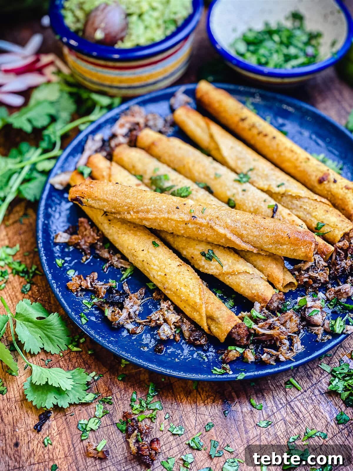 What to Make with Leftover Carnitas: Crispy Tacos & Bowls 8 leftover carnitas taquitos on a blue plate