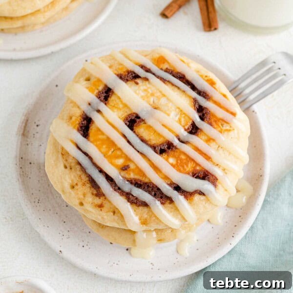 Quick Crescent Roll Cinnamon Swirl Rolls 7 Small stack of cinnamon roll pancakes with icing drizzled across it.