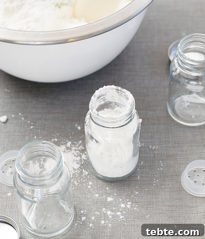 How to Make Natural DIY Body Powder at Home 7 A glass bottle jar with DIY Body Powder on it and two other empty glass bottle jars beside it and scattered powder on the table