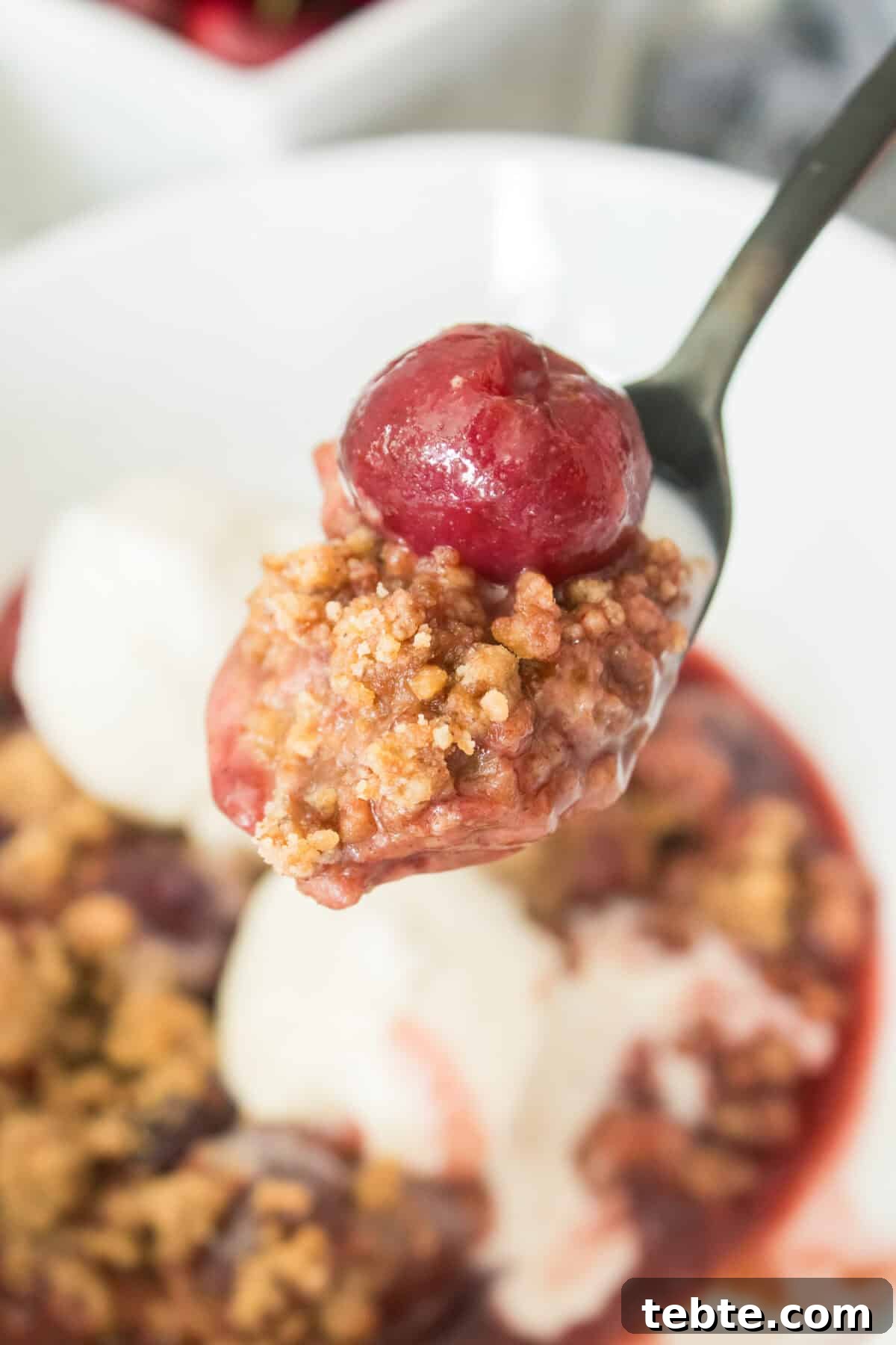 Gluten-Free Cherry Cobbler Recipe: Flaky Crust & Juicy Filling 2 close up vertical image of spoonful of cherry cobbler