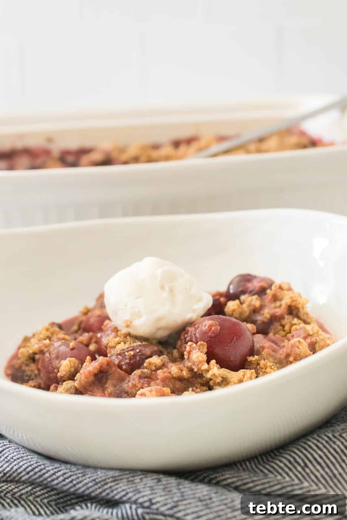 Gluten-Free Cherry Cobbler Recipe: Flaky Crust & Juicy Filling 10 vertical head on shot of cherry cobbler in bowl topped with scoop of vanilla ice cream