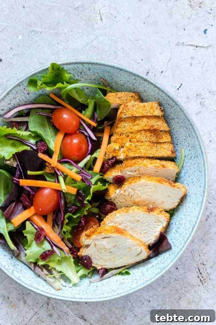 Air Fryer Chicken Breast sliced and served alongside a green salad
