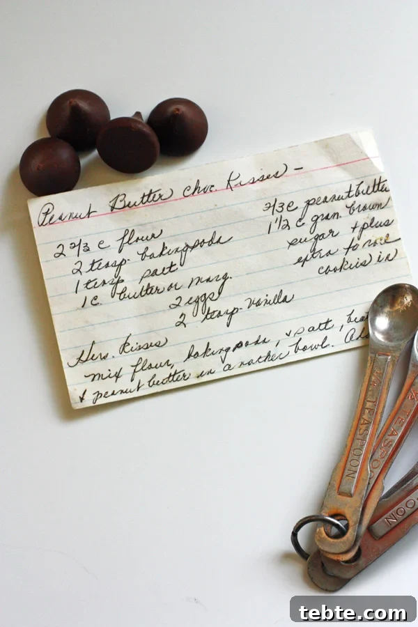 Peanut Butter Kiss Cookies Recipe — Chewy Chocolate-Stamped Treats 3 Recipe card hand written out sitting on white counter top