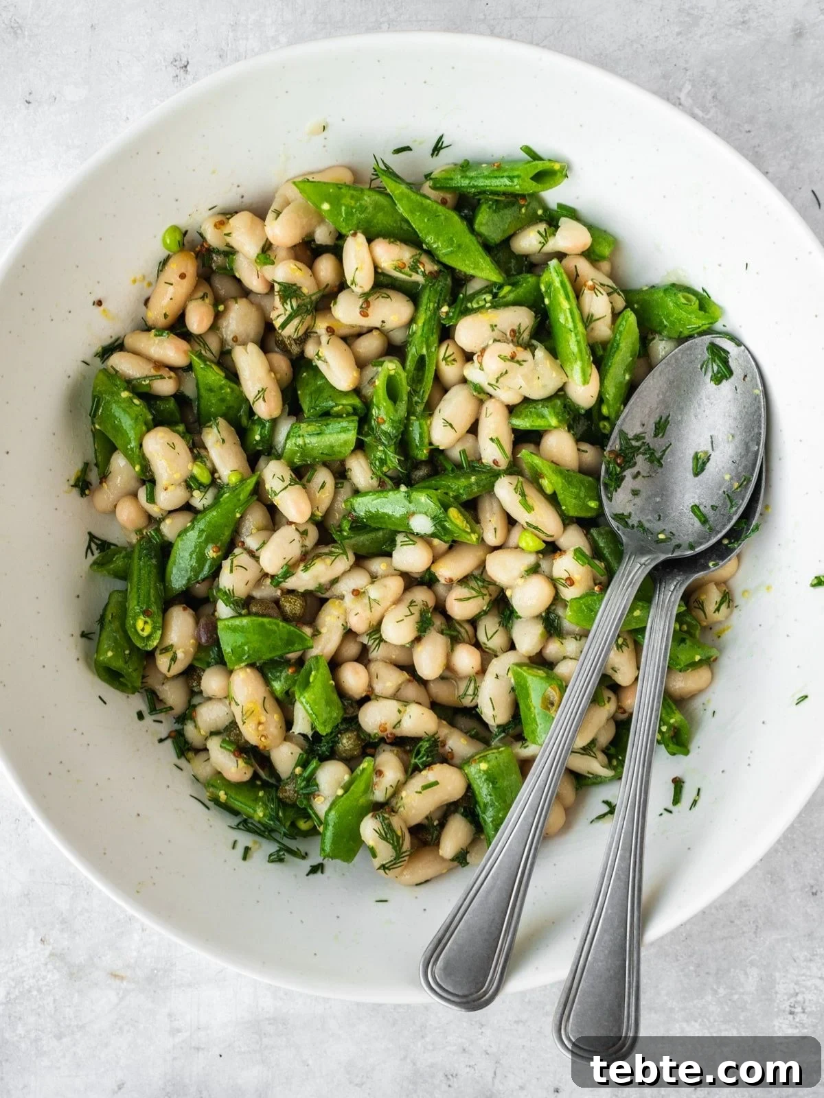 Grilled Asparagus and White Bean Salad with Lemon Vinaigrette 8 Bowl with chopped snap peas and beans tossed in the salad dressing.