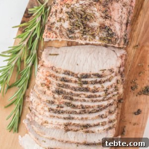 Rosemary Pork Roast with Garlic and Crispy Skin Recipe 2 rosemary pork roast sliced on wood board