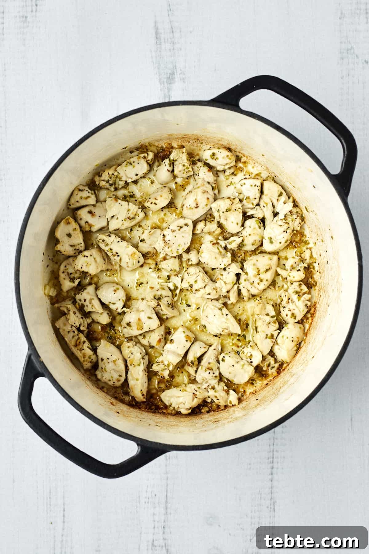 Creamy Tuscan Chicken Pasta Made in One Pot 3 Cooked, seasoned chicken in a large pot.