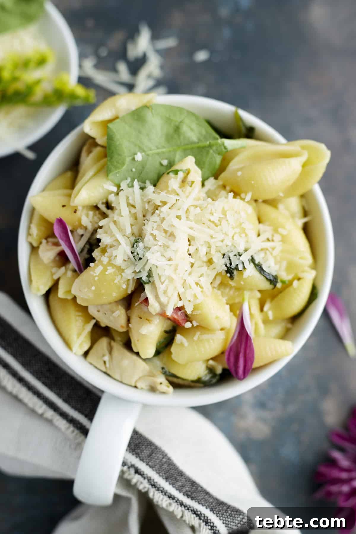 Creamy Tuscan Chicken Pasta Made in One Pot 8 a mug full of one pot creamy tuscan chicken pasta topped with grated Parmesan
