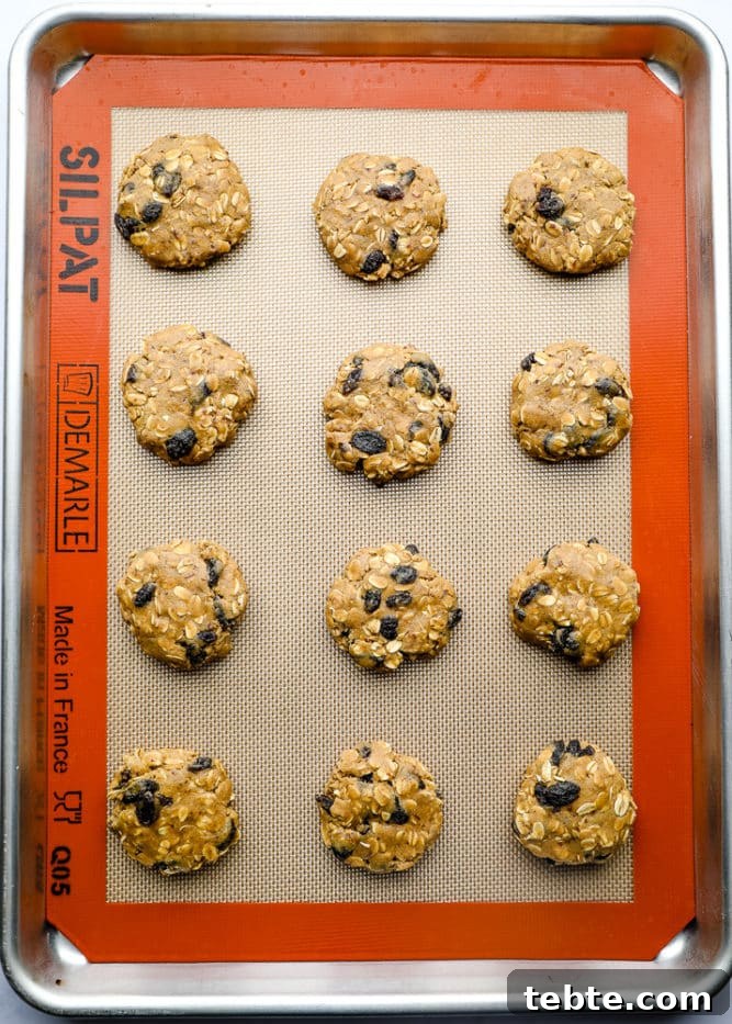 unbaked cookies on a silicone mat lined baking tray