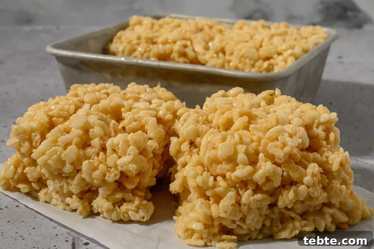 Small-Batch Rice Krispie Treats Recipe 8 Small Batch of Rice Krispie Treats on parchment paper and in a pan.