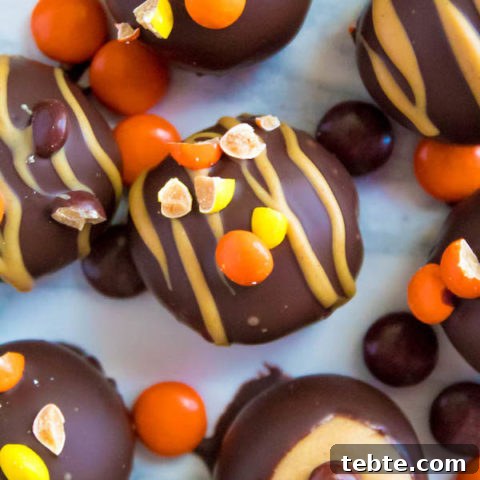 Reese's Pieces Peanut Butter Truffles— smooth and creamy peanut butter balls, loaded with mini Reese's Pieces, coated with dark chocolate and drizzled with melted peanut butter!