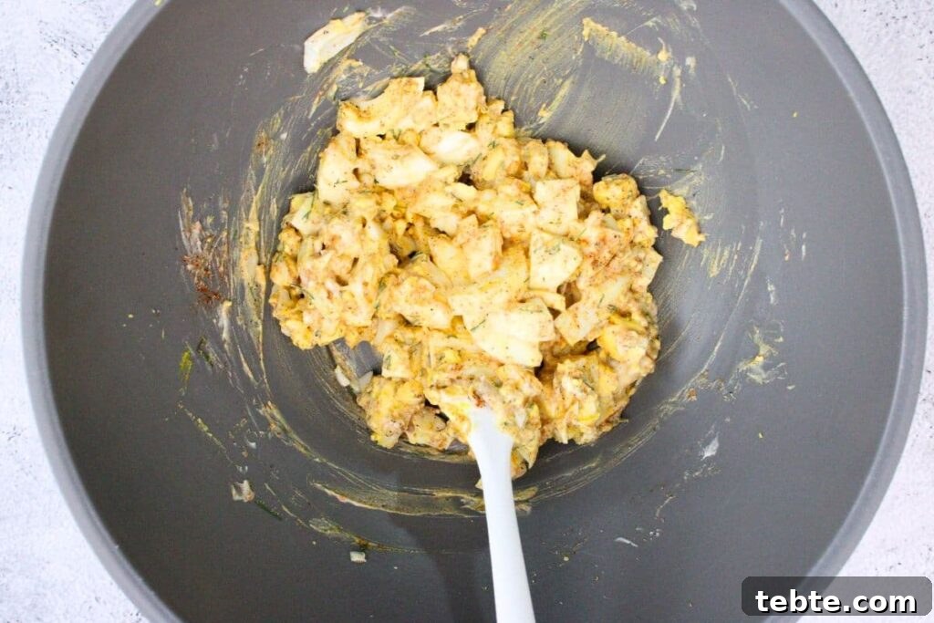 combine chopped eggs with mayonnaise, mustard, and seasonings